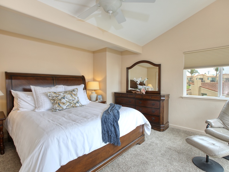 The master ensuite features a king bed with comfy white bedding, TV, and peek-a-boo ocean views.
