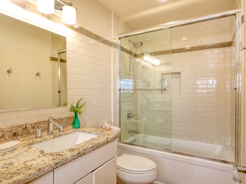 Just off the hallway, the second full bathroom features an updated tub/shower combination and is stocked with luxurious white towels and body soap.