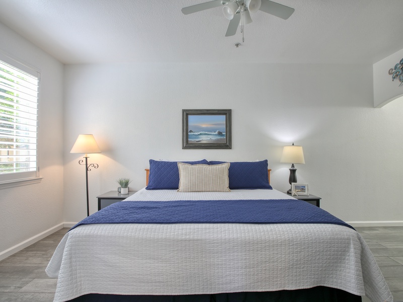 This inviting bedroom offers a comfortable king bed, calming coastal décor, and bright natural light for a relaxing retreat.