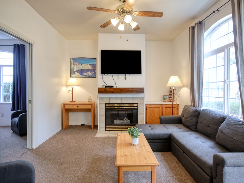 This cozy downstairs unit features a sectional couch, study space, a fireplace, and plenty of natural light.