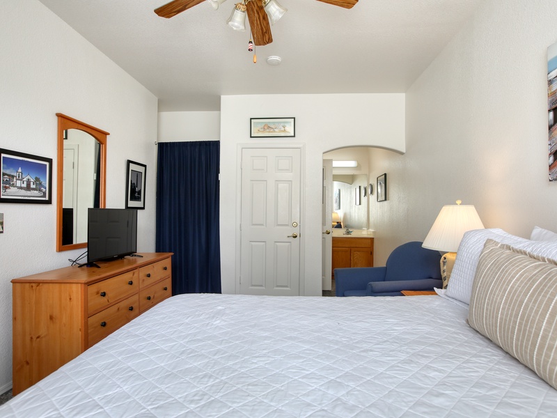 This inviting bedroom offers a comfortable king bed, calming coastal décor, and bright natural light for a relaxing retreat.