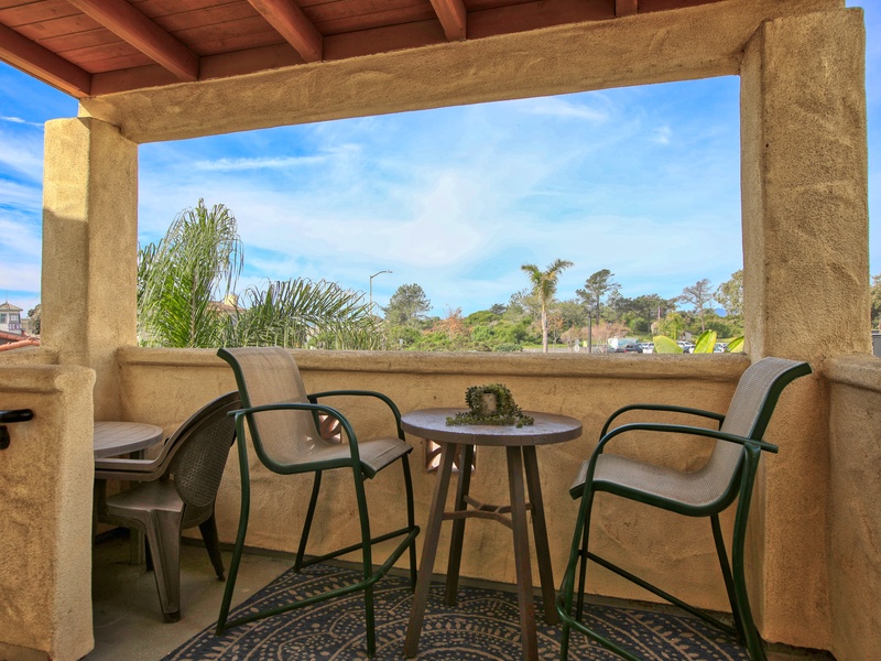 Unit #407 features a charming outdoor entry patio, complete with a high-top bistro set.