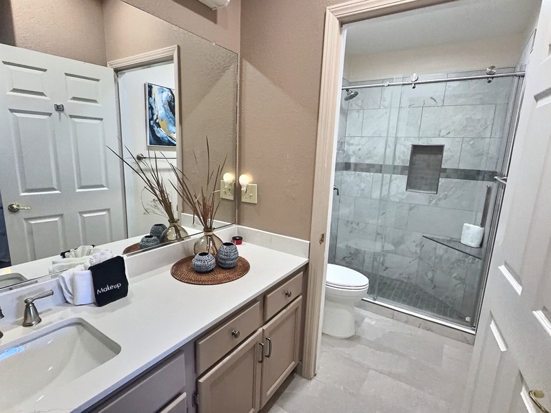 The bathroom boasts a stylish remodel, complete with a generous walk-in shower. This inviting upgrade showcases a soothing beach-inspired color palette, creating a tranquil retreat that enhances the overall atmosphere.