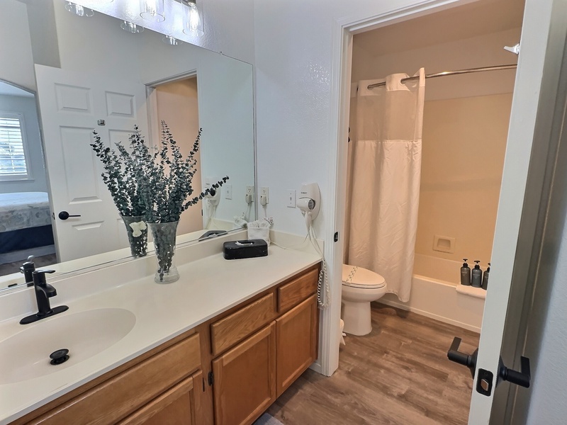 Rinse off the sand and salt in the spacious bathroom, featuring a roomy vanity and a relaxing tub/shower combo—perfect for unwinding after a sun-soaked day at the beach!