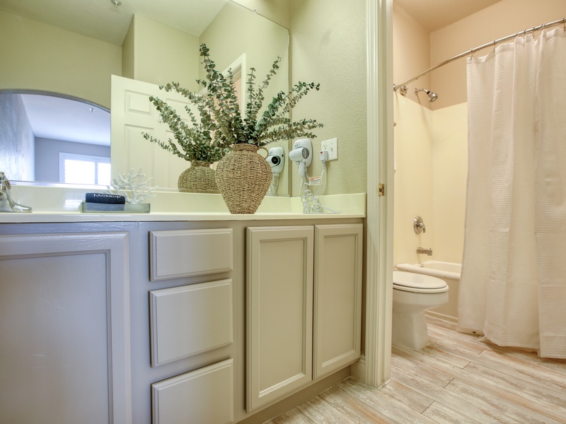 The bathroom features a tub/shower combination, plush white towels, and complimentary bath soaps, perfect for a refreshing start or a relaxing end to your day.