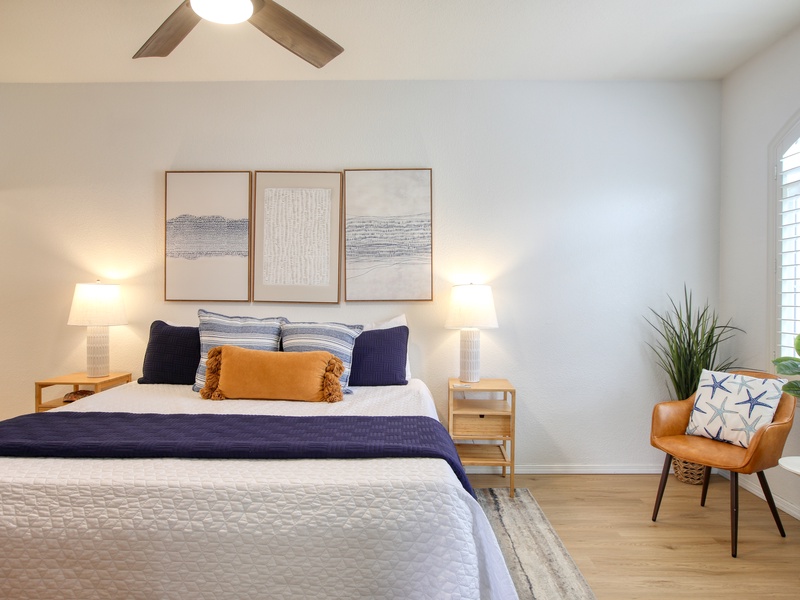Stylish and serene, the bedroom features a king bed dressed in soft white linens, creating a peaceful retreat for a restful night’s sleep.