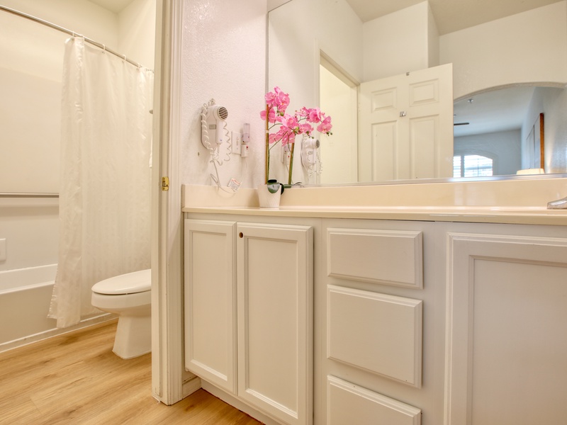 The bathroom includes a tub/shower combination, plush white towels, and complimentary bath soaps for a refreshing start or relaxing end to your day.