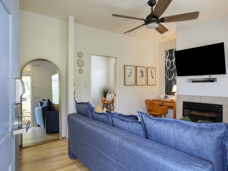 The living room offers a queen sleeper sofa, work desk, and fireplace—perfect for relaxing after a day at the beach.
