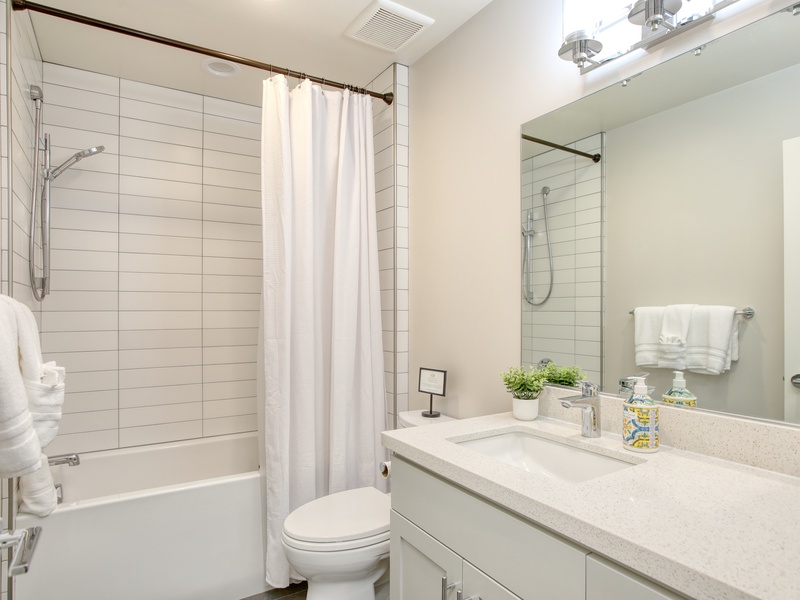 Shown here is the third full bathroom, conveniently situated in the hallway just off the living room.