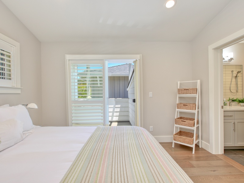 The junior suite’s bathroom features a convenient tub/shower combination, offering flexibility for a quick rinse or a relaxing soak. In the distance, you can catch a glimpse of the private balcony, adding an inviting touch of outdoor living to the space.
