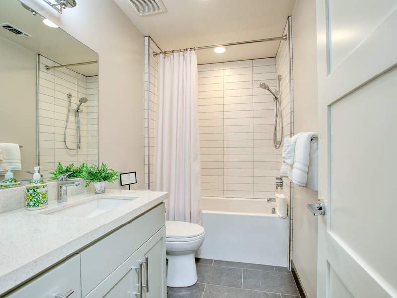 The second bedroom’s ensuite bathroom is roomy and includes a tub/shower combination. It provides ample space to move freely and has beach-inspired finishes.