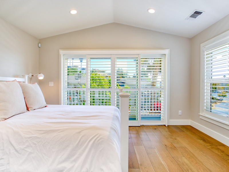 The master ensuite has a luxurious king-size bed dressed in crisp white linen bedding, offering both elegance and comfort.