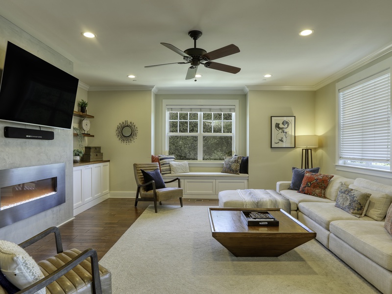The cozy great room hub (sectional sofa, fireplace, and flat-screen TV) offers direct access to the large, fully-decked outdoor space. Enjoy the gas BBQ and seating nestled beneath beautiful live oak trees.